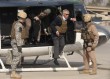 U.S. Defense Secretary Hagel wears body armor as he steps off a helicopter in Baghdad